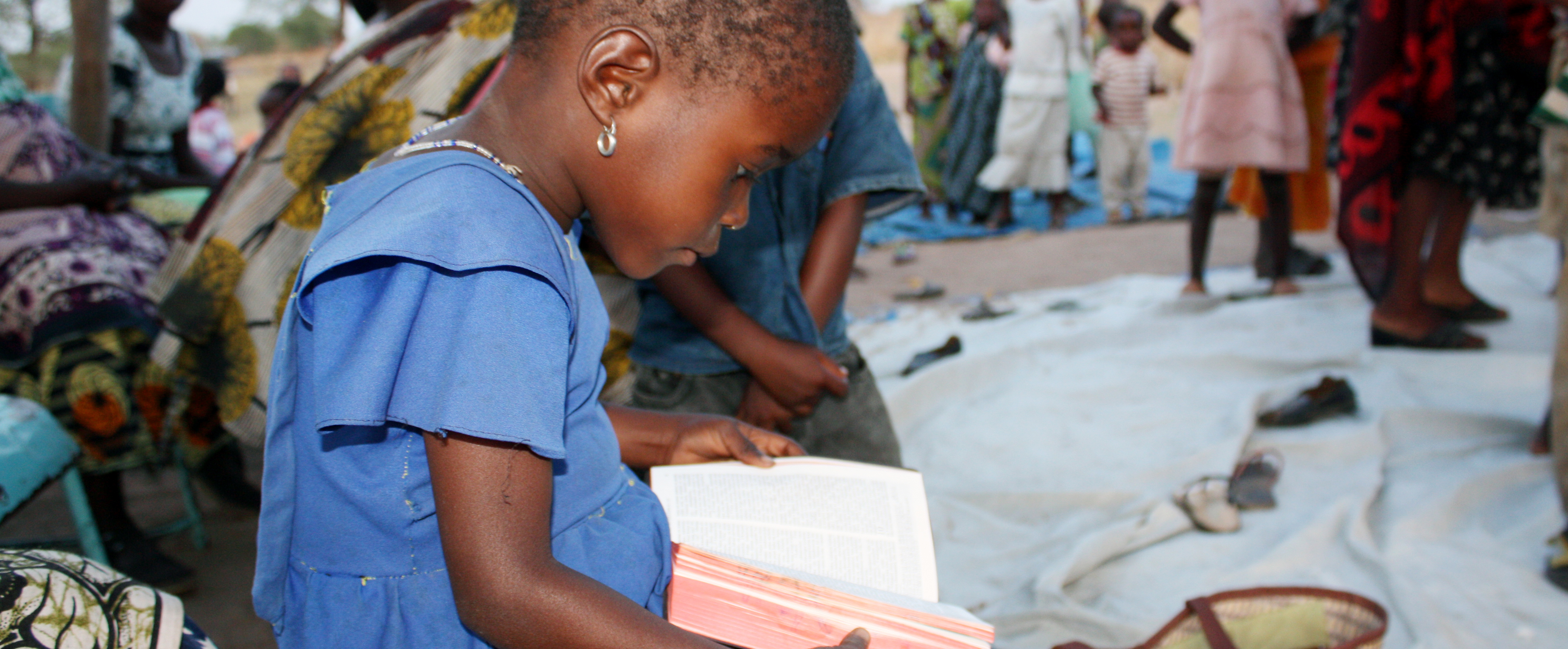 Lapsi tutkii Raamattua Tansaniassa.
