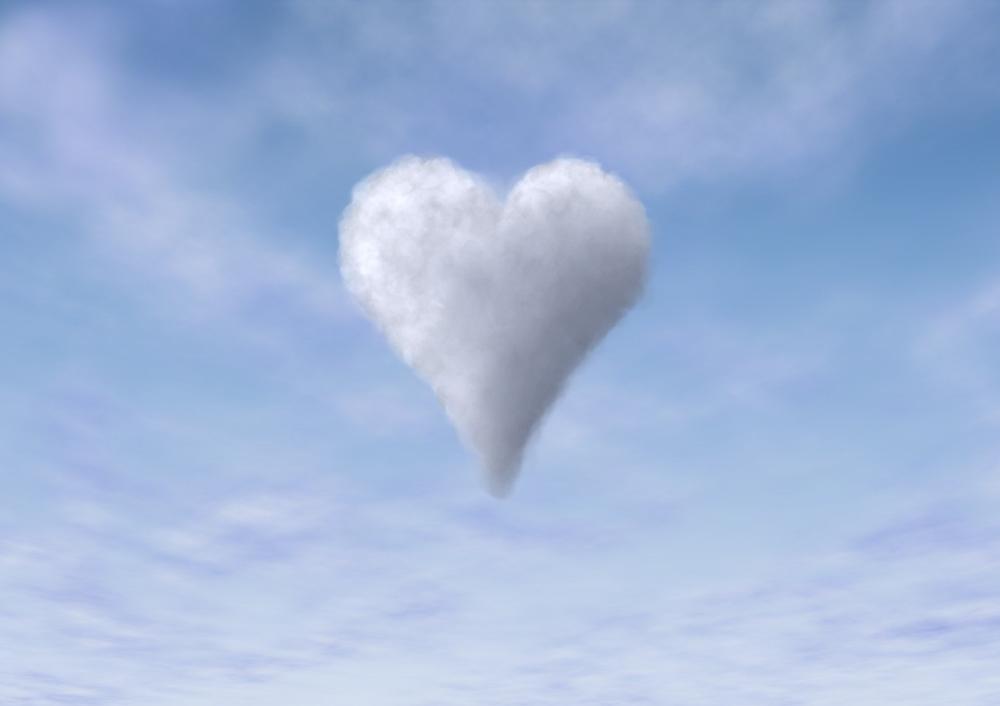 Sydämenmuotoinen valkoinen pilvi sinisellä taivaalla.
